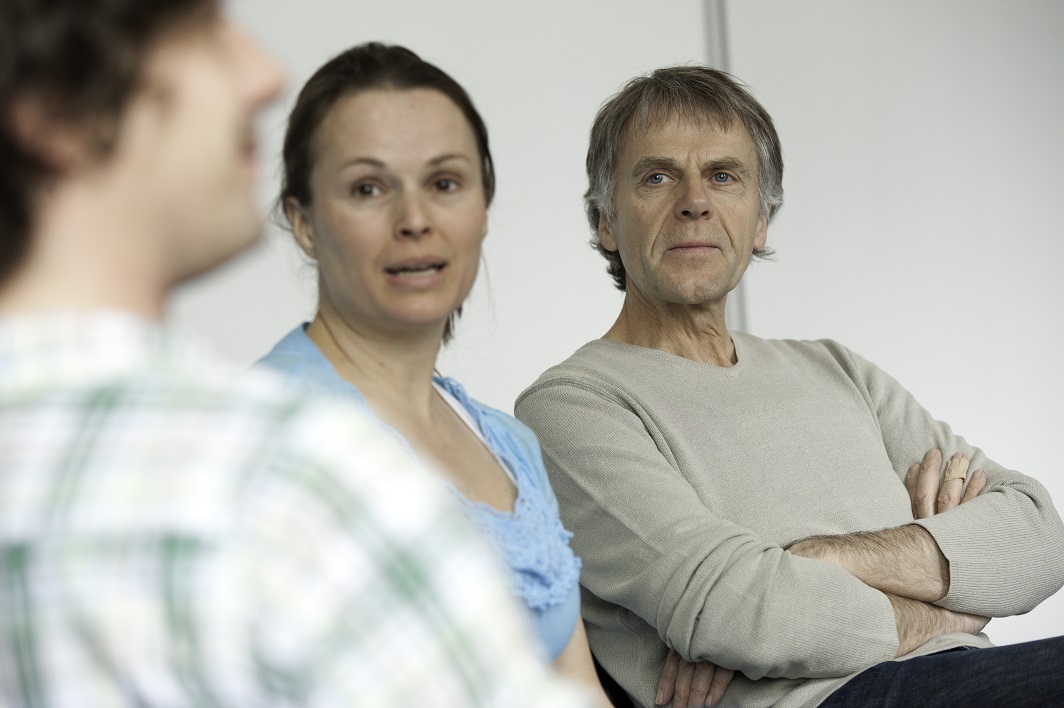 Auf dem Foto abgebildet sind eine Frau und zwei Männer während einer Gruppentherapie.