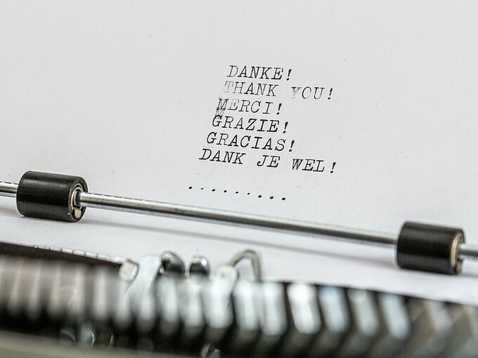 Das Foto zeigt einen Schreibmaschinen-Text, auf dem das Wort "Danke" auf verschiedenen Sprachen steht.